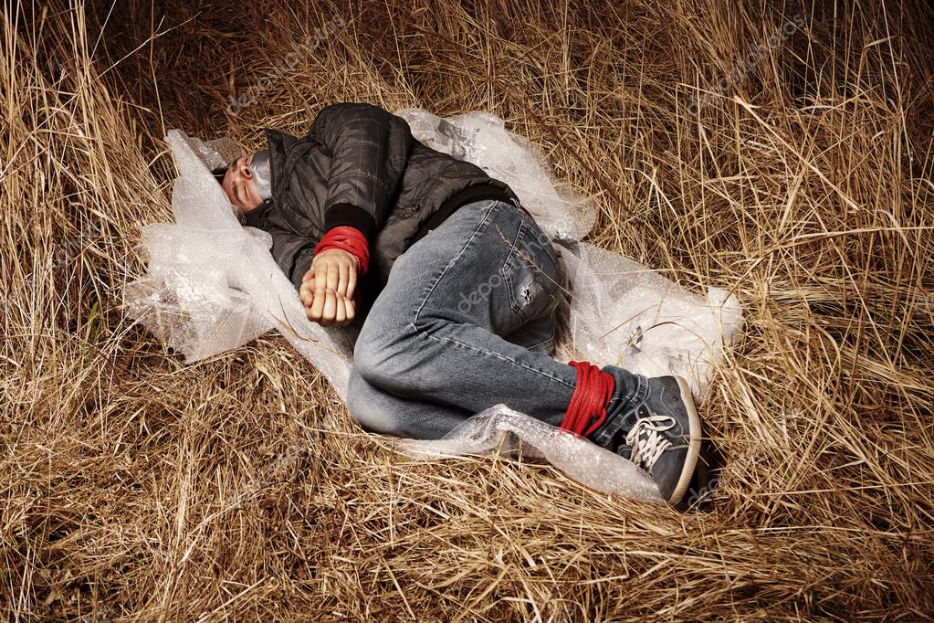 Kidnapped hitchhiker left in winter grass Stock Photo by ©Couperfield