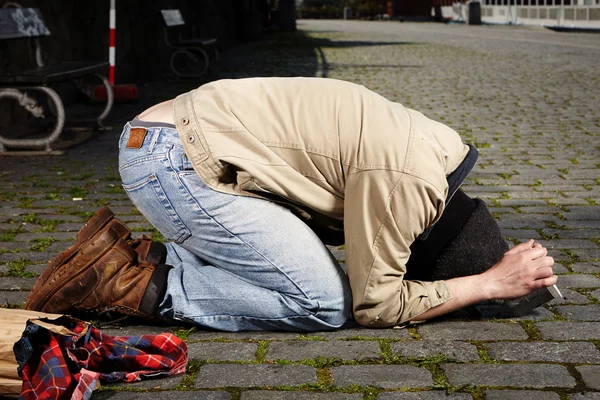 Beggar on knees — Stock Photo, Image