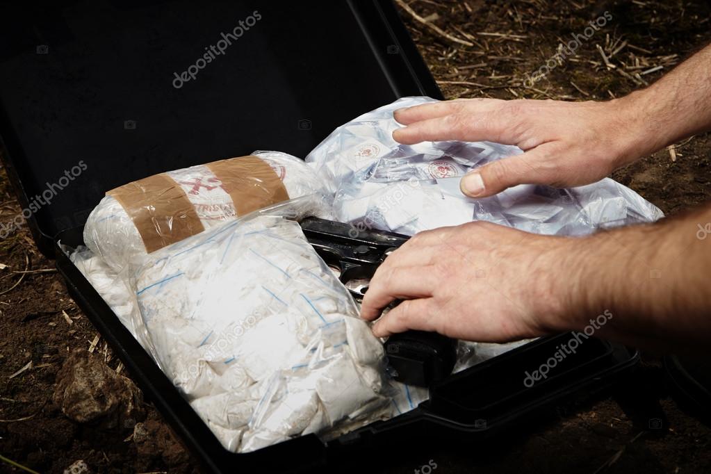 Hombre escondiendo drogas en la maleta fotografía de stock