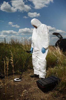 Criminologist technician at work with metal detector