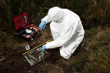 Criminologist technician on hiding place