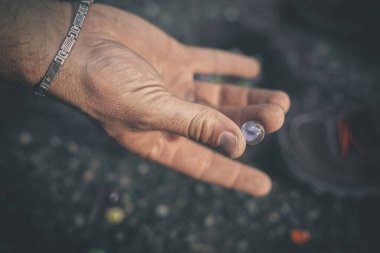 Yetişkin bir adam ve oğlu doğada klasik misketleri eğitiyorlar.