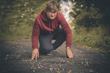 Yetişkin bir adam ve oğlu doğada klasik misketleri eğitiyorlar.