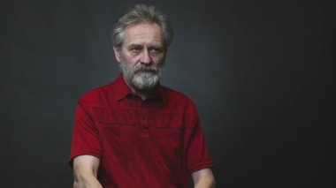 Yaşı ilerlemiş yaşlı bir adam arka planda izole edilmiş tabancayla operasyon yapıyor.