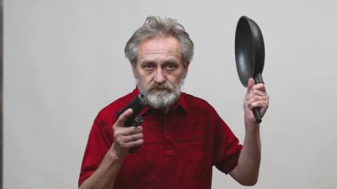 Yaşı ilerlemiş yaşlı bir adam arka planda izole edilmiş tabancayla operasyon yapıyor.