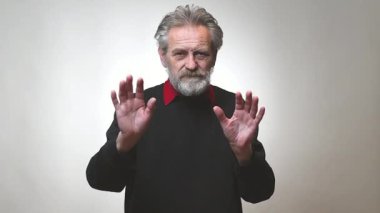 Yaşı ilerlemiş yaşlı bir adam arka planda tek başına el sallıyor.