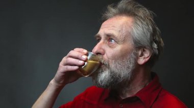 Yaşı ilerlemiş yaşlı bir adam arka planda tek başına yiyip içiyor.