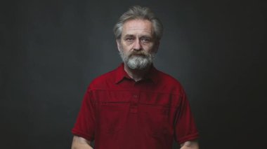 Yaşı ilerlemiş yaşlı bir adam arka planda izole edilmiş tabancayla operasyon yapıyor.