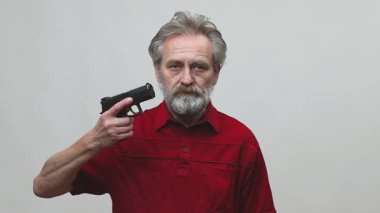 Yaşı ilerlemiş yaşlı bir adam arka planda izole edilmiş tabancayla operasyon yapıyor.