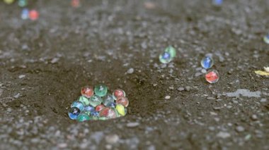 Dışarıda, tozlu yolda ağır çekimde misket oynamanın ayrıntıları