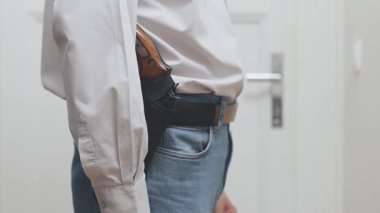 Evde silahını çeken silahlı bir insan ayrıntısı.