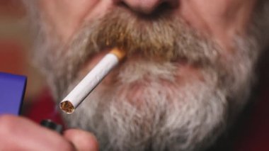 Yaşlı adam balkonda sigara içiyor. Detaylı video çekimlerinde klasik sigara.