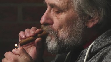 Yaşlı adam balkonda sigara içiyor. Detaylı video görüntülerinde büyük bir puro.