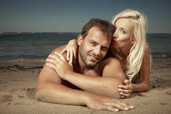 Loira senhora e seu homem na praia — Fotografia de Stock