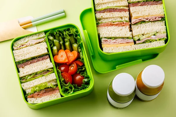 Japanese sandwiches Sando and vegetable salad in lunch box on green table background