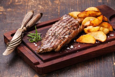 Well done grilled New York steak with roasted potato