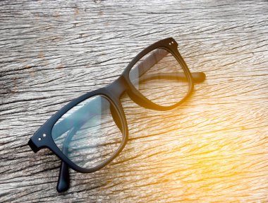 Ahşap arka planda mor gözlük ve patlamış ışık.