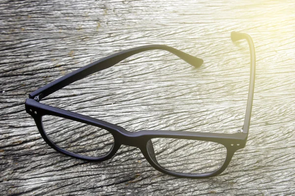 Black Eye Glasses Wood Background Burst Light — Stock Photo, Image