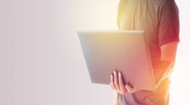 Dizüstü bilgisayarı patlamış ışıkla tutan adam.