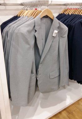 Erkekler elbise mağazasında asılı duruyor.