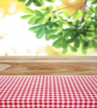 Damalı masa örtüsü ve bulanık yapraklar arka plan