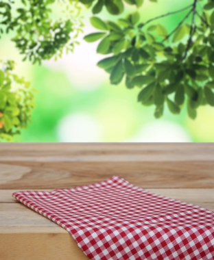 Damalı masa örtüsü ve bulanık yapraklar arka plan