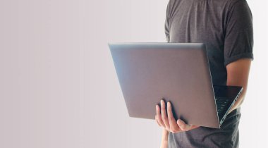 Dizüstü bilgisayarı tutan adam.