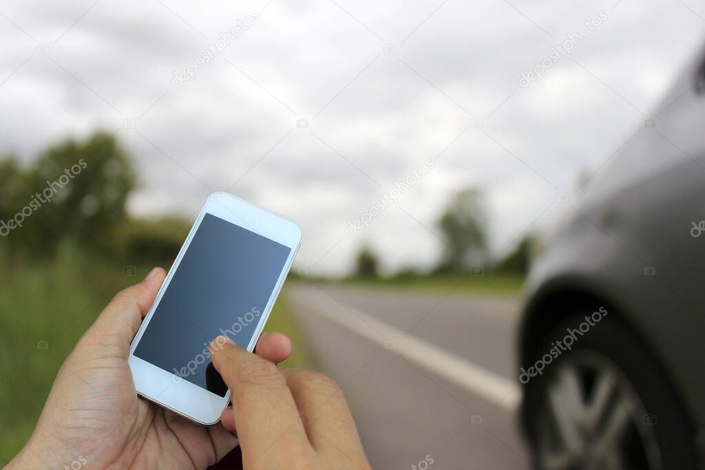 hand holding the smartphone on blur of Road running through the way
