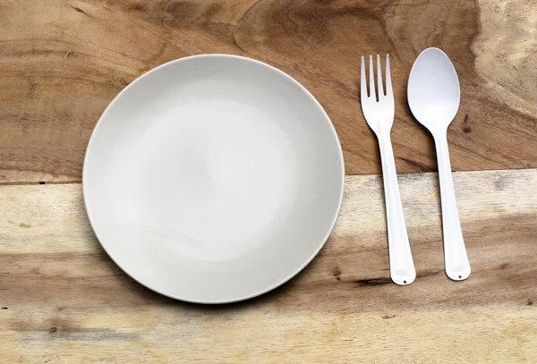 Empty plate with spoon and fork ,top view. on wood background — Stock Photo, Image