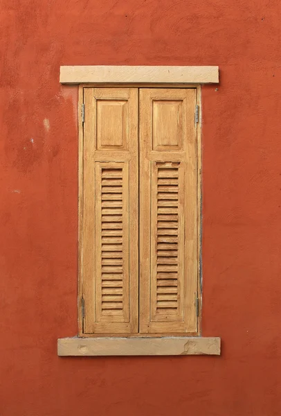Janela de madeira na parede vermelha — Fotografia de Stock