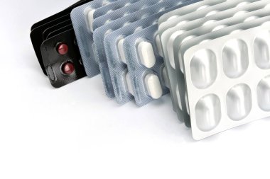 Beyaz arkaplanda folyo paketlerindeki tabletler