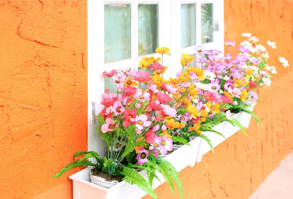 Квіткова коробка у вікні помаранчевої будівлі — стокове фото