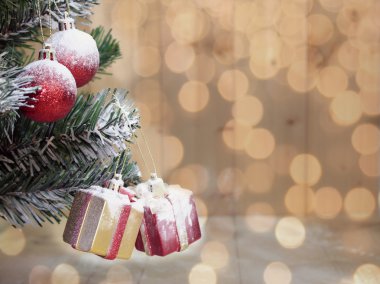 Arkaplanda Noel ağacı ve fiyonklu şirin hediye kutuları