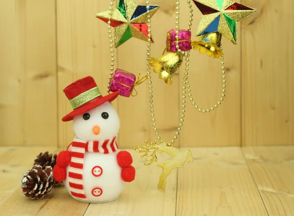 Toy snowman  is standing beside Christmas decoration — Stock Photo, Image