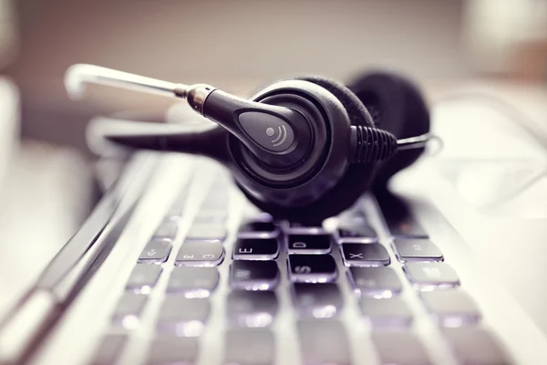 Headset auf einer Laptop-Computertastatur — Stockfoto