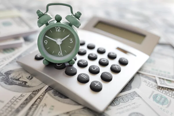 Calculator and alarm clock on money — Stock Photo, Image