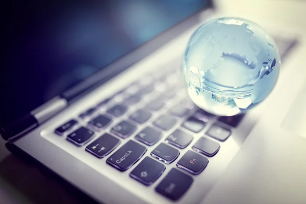 Кришталевий глобус на клавіатурі ноутбука — стокове фото