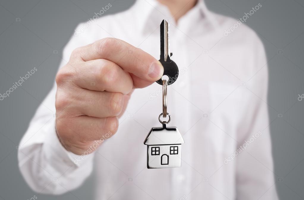 Man holding out house key