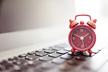 Alarm clock on laptop clipart
