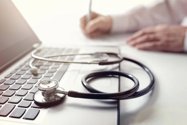 Médico escrevendo notas de paciente — Fotografia de Stock