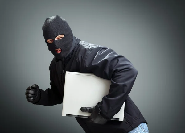 Thief stealing laptop computer — Stock Photo, Image