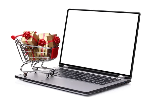 Přenosný počítač s nákupním vozíkem plným dárek — Stock fotografie