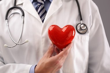 Doktor holding kalp göğüs karşı
