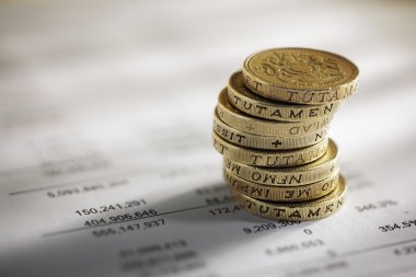Stack of pound coins on financial figures clipart