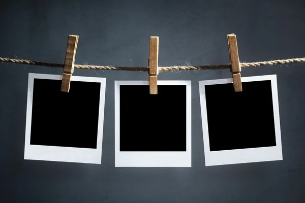 Fotografías en blanco colgando de un tendedero — Foto de Stock