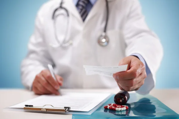 Médico que dá uma receita a um paciente — Fotografia de Stock