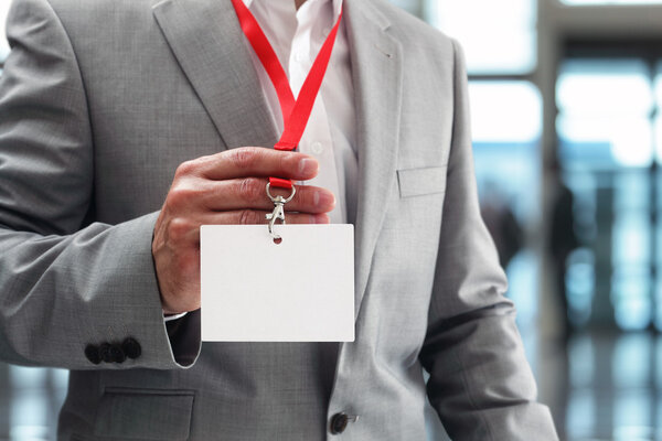 Businessman holding blank ID badge