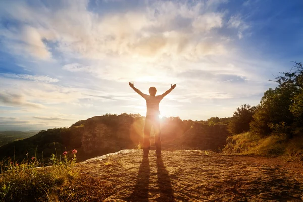 Uomo con le mani alzate al tramonto — Foto Stock