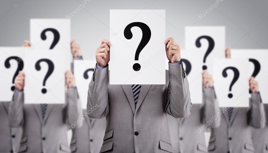 Business colleagues holding question mark signs