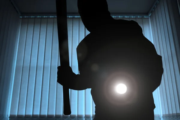 Inbrottstjuv med ficklampa och baseball bat — Stockfoto